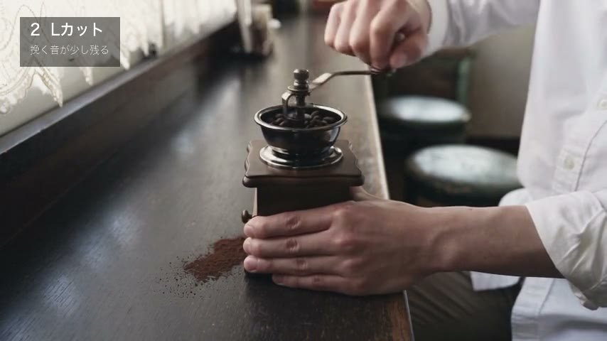 手回しのミルで豆を挽く手元
